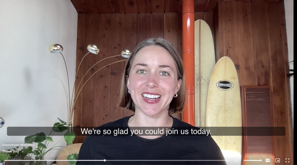 Include automated English and Spanish transcription A video of a young smiling woman, with closed captions reading 'We're so glad you could join us today."